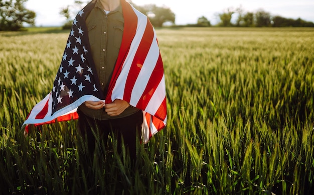 L'uomo tiene sventolando la bandiera americana degli Stati Uniti Patriot alza la bandiera nazionale americana Independence Day 4 luglio