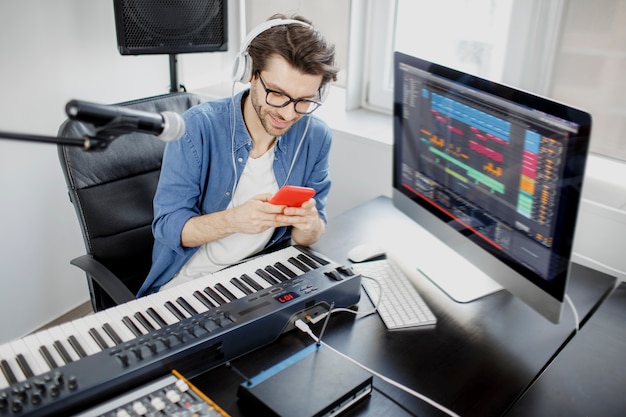 L'uomo tiene uno smartphone tra le mani in studio