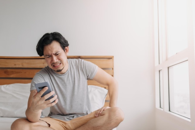 L'uomo triste ha cattive notizie sulla chat online e si sente deluso dallo smartphone