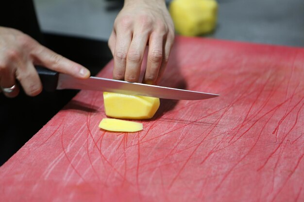 L'uomo trita le patate per cucinare.