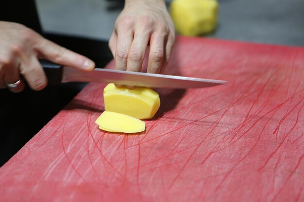 L'uomo trita le patate per cucinare.