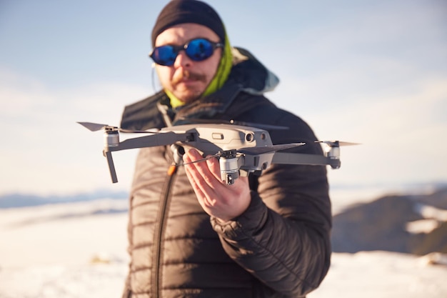 L'uomo turistico lancia un drone quadricottero in montagna Percorsi turistici invernali nelle montagne dei Carpazi Ucraina