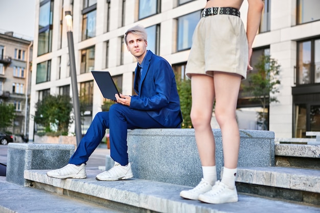 L'uomo vestito con il laptop ha litigato con la ragazza all'aperto