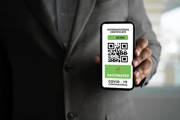 L'uomo viaggia sulla mappa del passaporto dell'immigrazione per mostrare un certificato di vaccinazione contro il Covid-19 in aeroporto