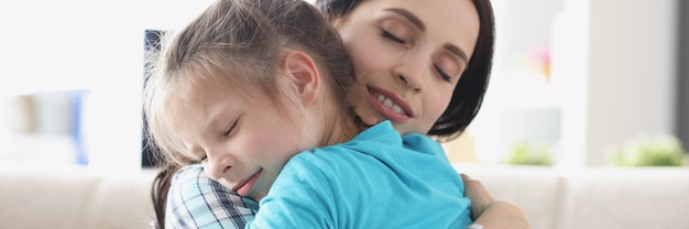 La bambina abbraccia insieme a sua madre in un abbraccio gentile