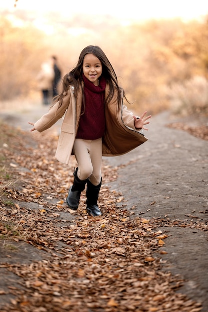 La bambina adorabile felice corre nel parco autunnale. infanzia felice