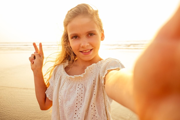 La bambina affascinante viene fotografata al telefono