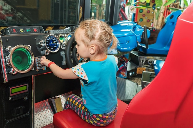 La bambina al volante del simulatore di gioco preme i pulsanti