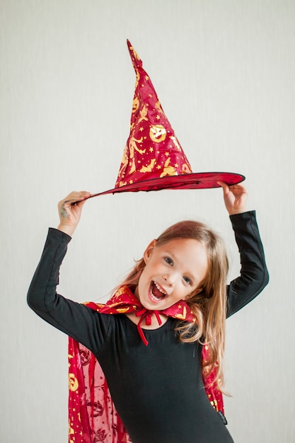 La bambina allegra gioca e si diverte in un costume da strega di carnevale