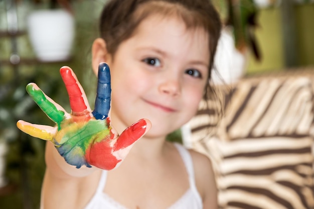 La bambina allungava la mano dipinta con colori colorati