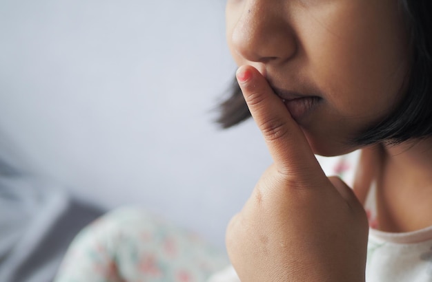 la bambina alza la mano per indicare di smettere di parlare o di stare zitta.