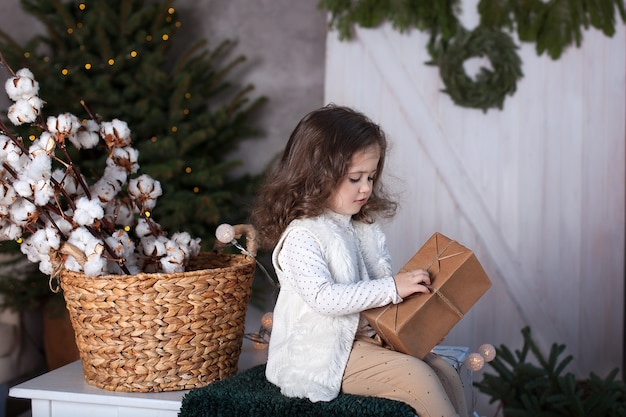 La bambina apre un regalo a Natale