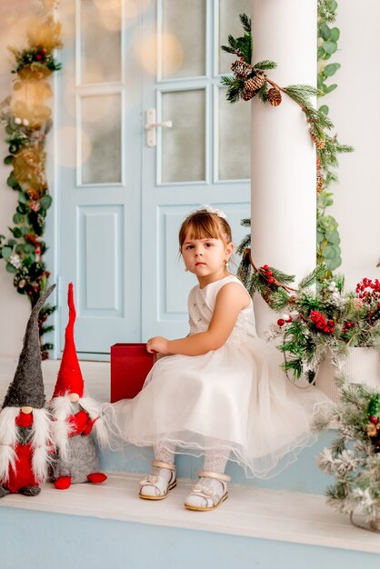 La bambina apre un regalo di Natale.