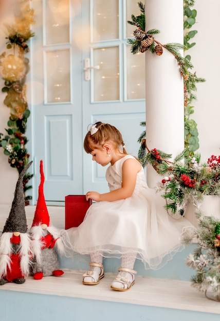 La bambina apre un regalo di Natale.