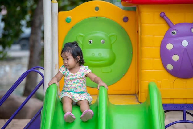 La bambina asiatica gioca con il divertimento al parco giochiGente della ThailandiaRagazza carina