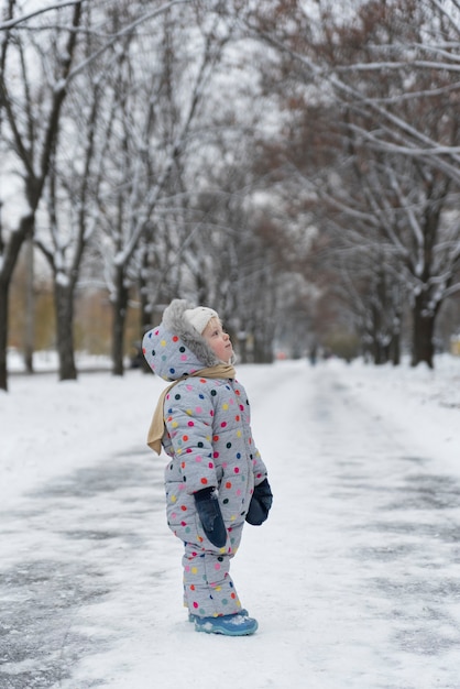 La bambina cammina a winter park. Cornice verticale.
