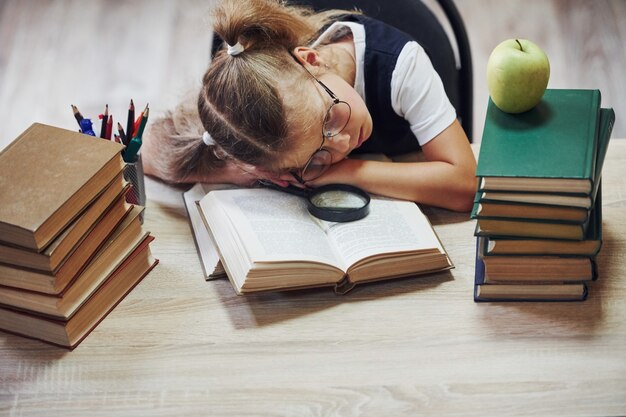 La bambina carina con le trecce è in biblioteca