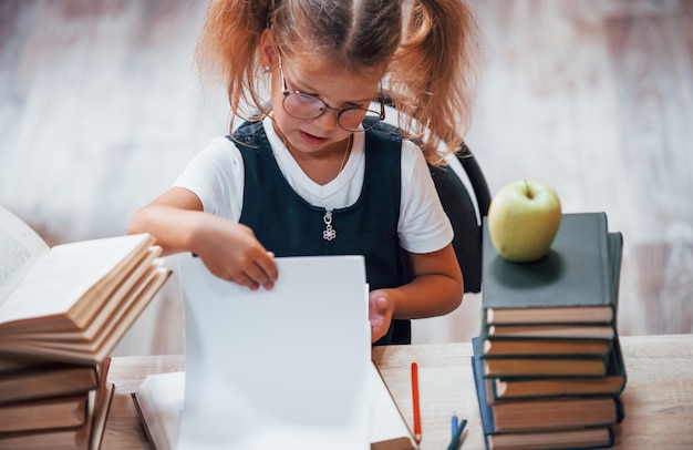 La bambina carina con le trecce è in biblioteca