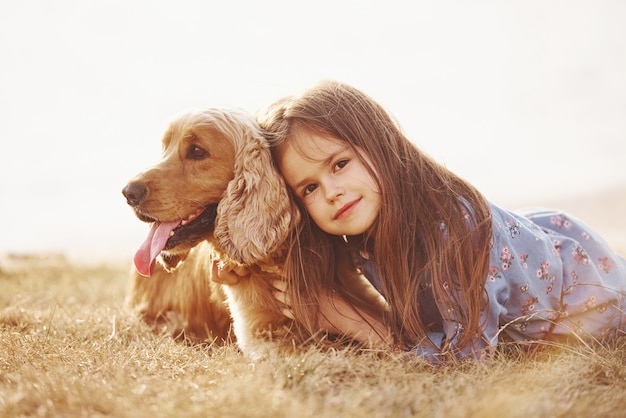 La bambina carina fa una passeggiata con il suo cane all'aperto in una giornata di sole