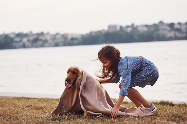 La bambina carina fa una passeggiata con il suo cane all'aperto in una giornata di sole