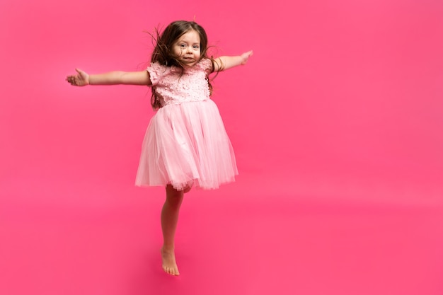 La bambina carina sogna di diventare una ballerina. Piccola ragazza che balla. Studio Tiro Su Sfondo Rosa.