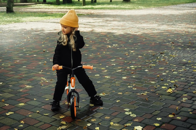 La bambina carina va in bicicletta al parco