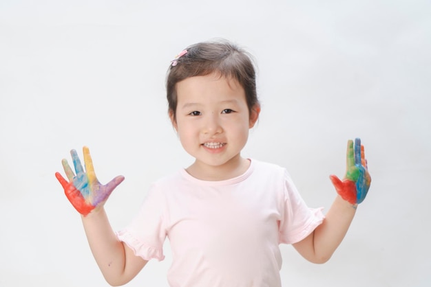 La bambina cattiva si coprì le mani e il viso con la vernice