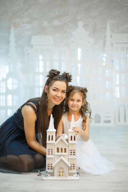 La bambina con la mamma gioca in una favolosa città bianca