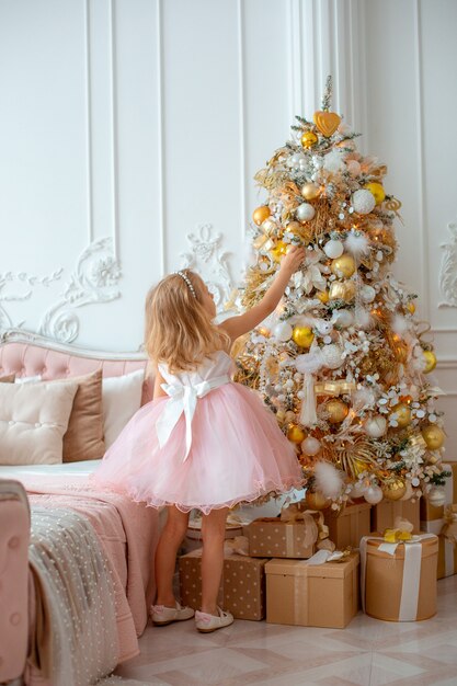 La bambina decora l'albero di Natale a casa