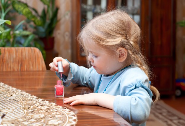 La bambina dipinge le unghie