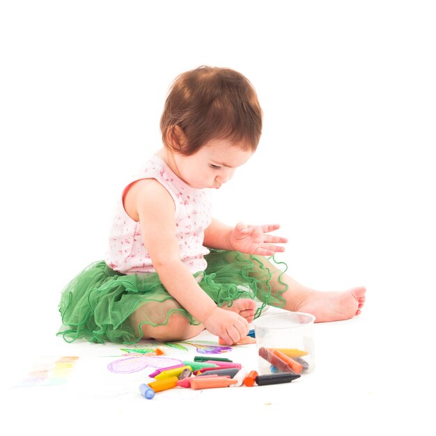 La bambina disegna con i pastelli a cera sulla carta