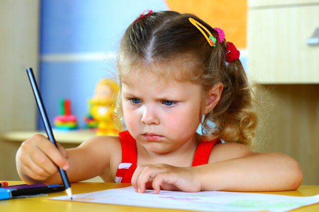 La bambina disegna con i pastelli