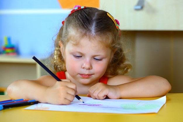 La bambina disegna con i pastelli