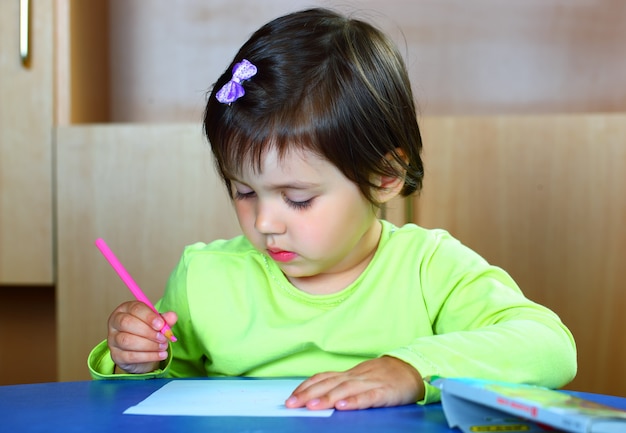 La bambina disegna con i pastelli