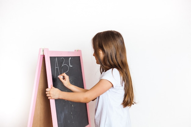 La bambina disegna il bordo di gesso