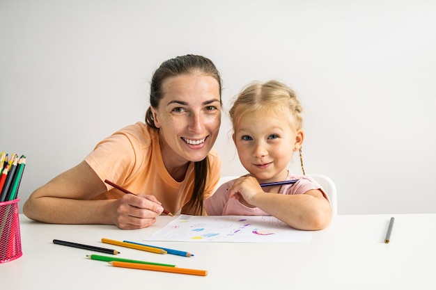 La bambina e la madre sorridenti sono dipinte con matite colorate su carta