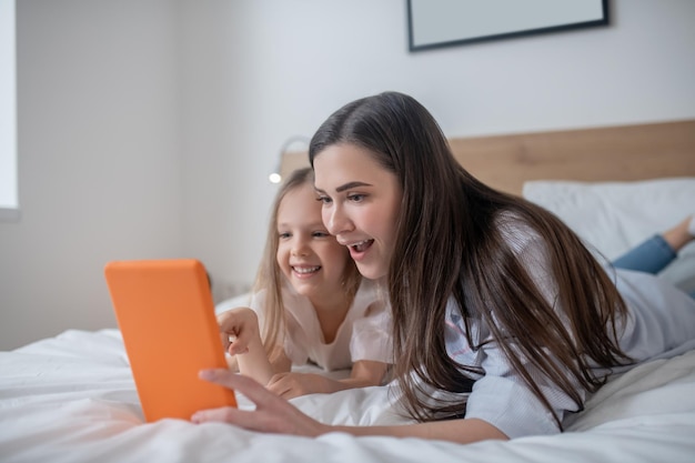 La bambina e la sua mamma stupita guardano il tablet