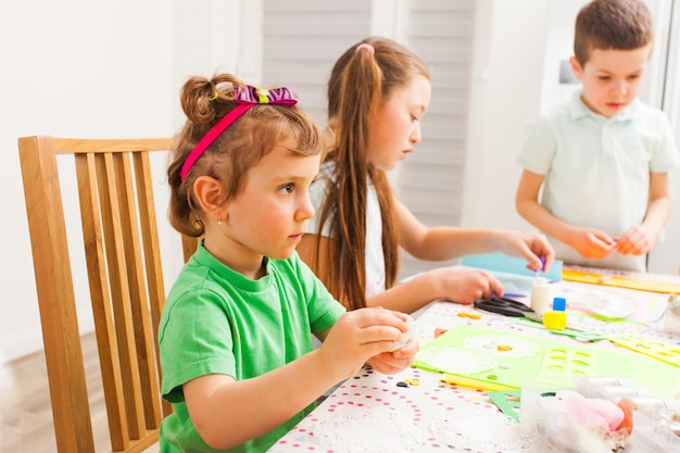 La bambina fa artigianato in una masterclass davanti ad altri bambini