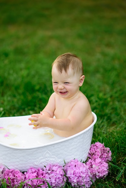 La bambina fa il bagno in un bagno di latte nel parco