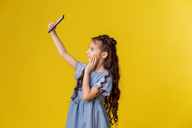 La bambina fa selfie al telefono.