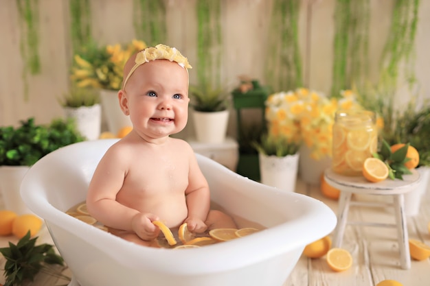 La bambina felice bagna nella vasca da bagno