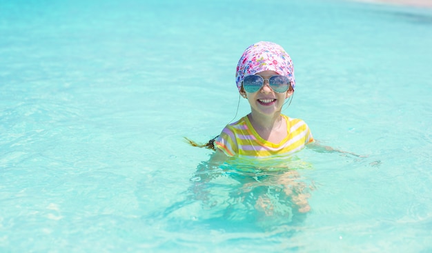 La bambina felice si diverte al mare durante le vacanze estive