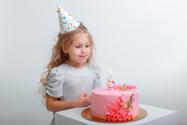 La bambina festeggia il suo compleanno spegnendo le candeline su una torta