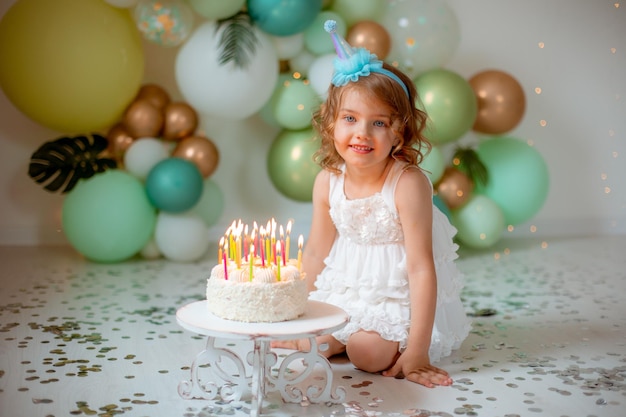 La bambina festeggia il suo compleanno sullo sfondo di palloncini che spengono le candeline