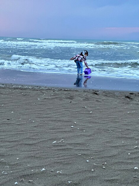 La bambina gioca con la sabbia in spiaggia