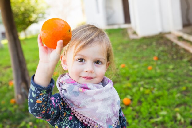 La bambina gioca con le arance. Alimenti e dieta sani