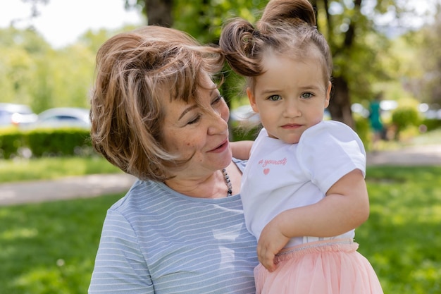 la bambina gioca e cammina nel parco con gli abbracci del passatempo della famiglia dei nonni