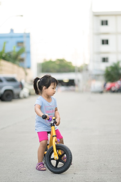 La bambina impara a pedalare in bicicletta sulla strada