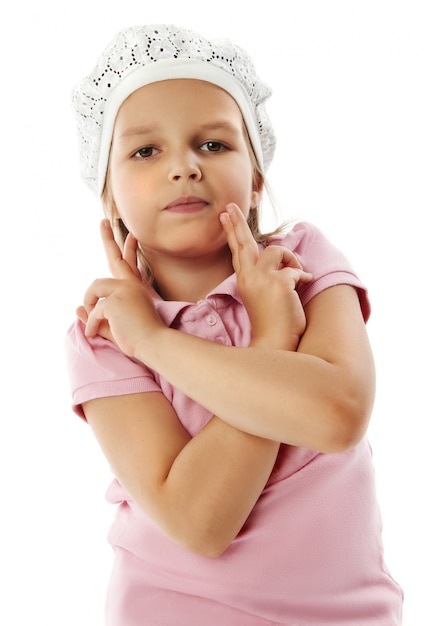 La bambina in camicia rosa colpisce una posa che esamina la macchina fotografica