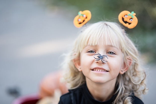 La bambina in costume da strega celebra Halloween all'aperto e si diverte.